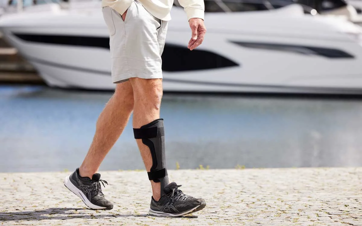 Beskuren bild på en person som bär en ToeOFF droppfotsortos.